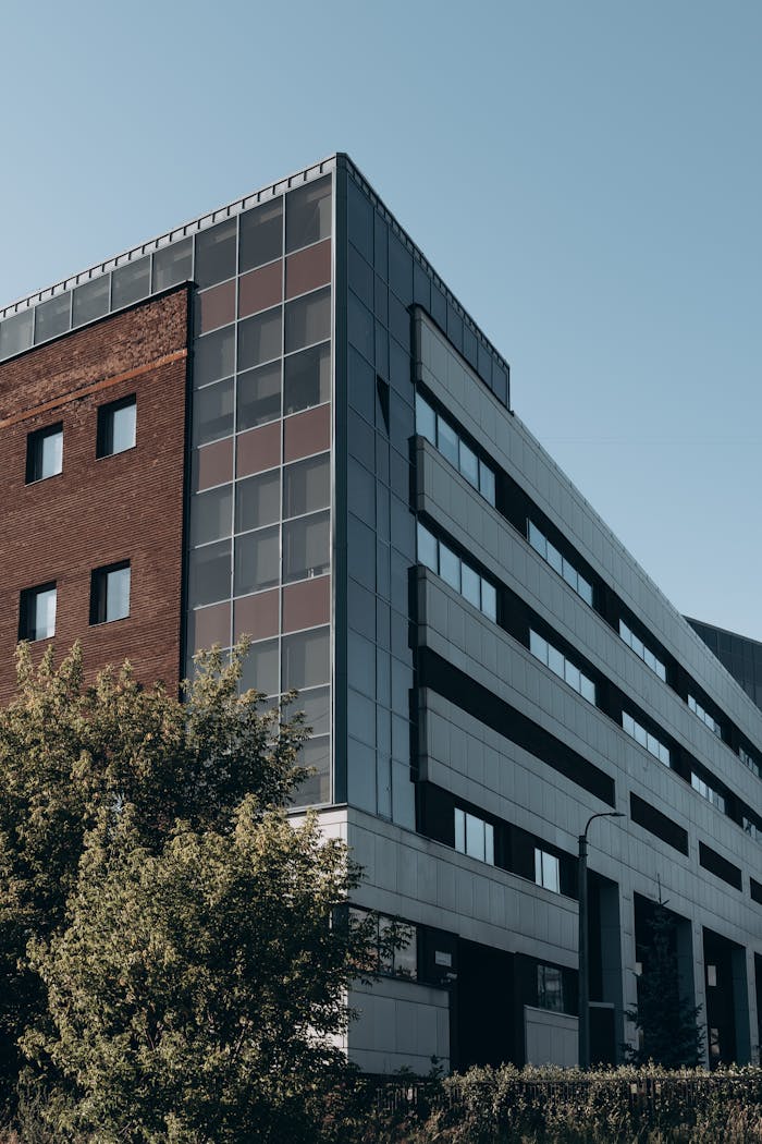 portfolio-04 Contemporary urban building blending brick and metal architecture with greenery.