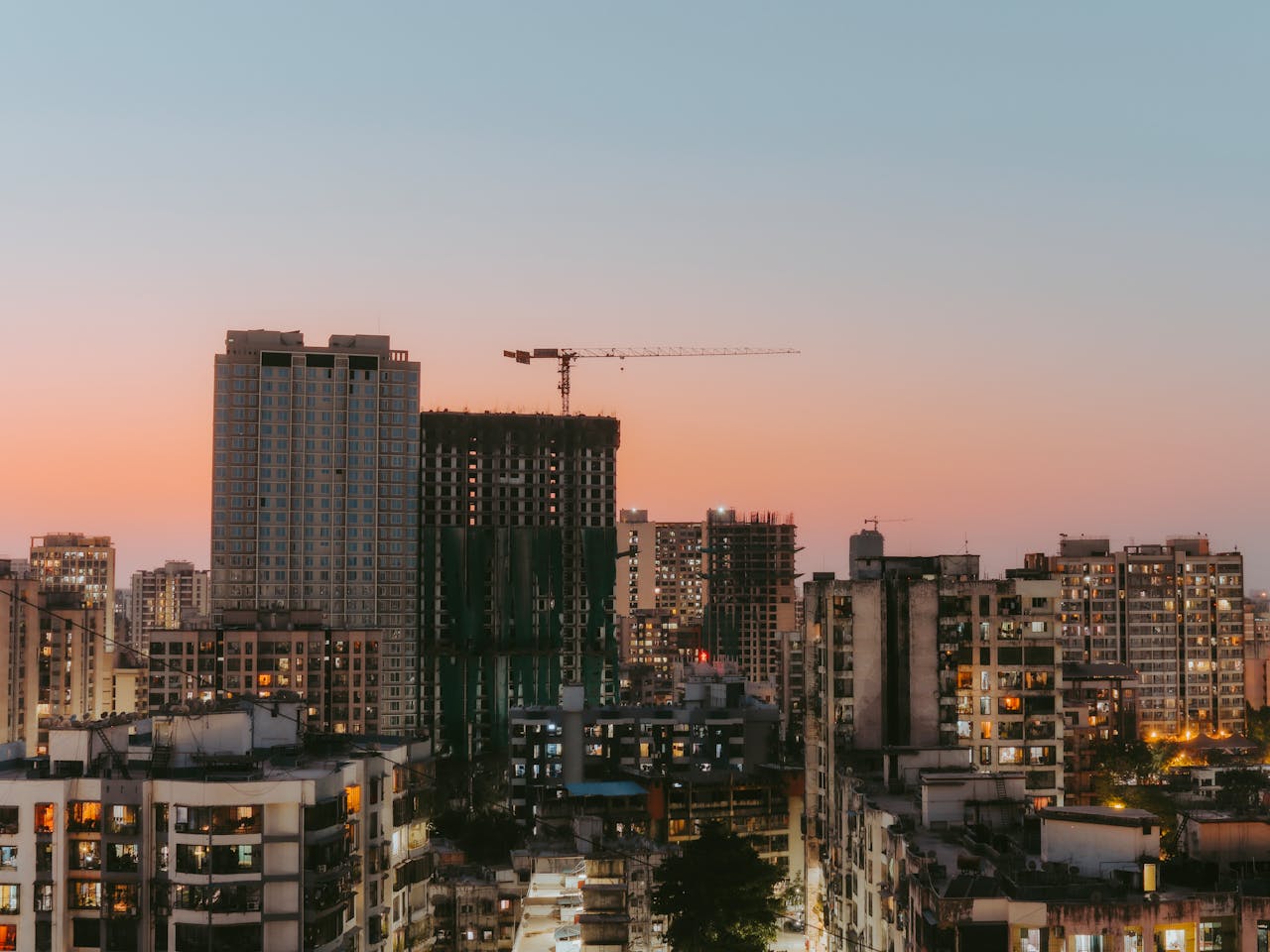 Mastering the First Impression: Your intriguing post title goes here Cityscape view with buildings and a construction crane at sunset, highlighting urban development.