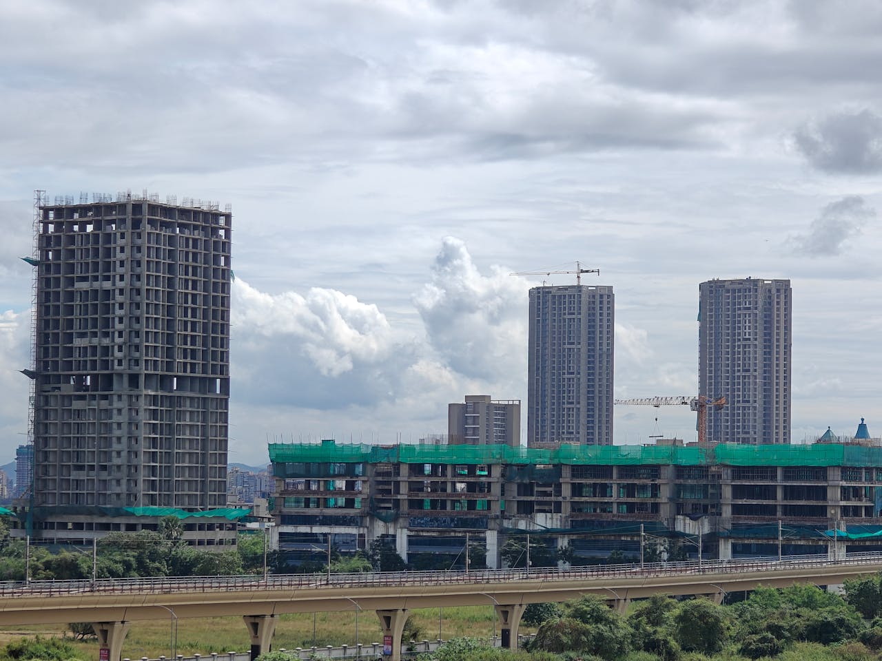 The Art of Drawing Readers In: Your attractive post title goes here Cityscape featuring high-rise buildings under construction with cranes.